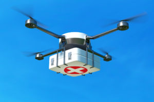 Drone with first aid kit on blue sky.